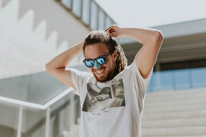 Long hair guy tying hair back with colorful sunscreen